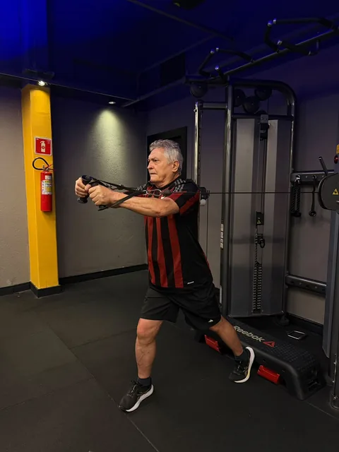 Exercício em pé com cabos e braços à frente